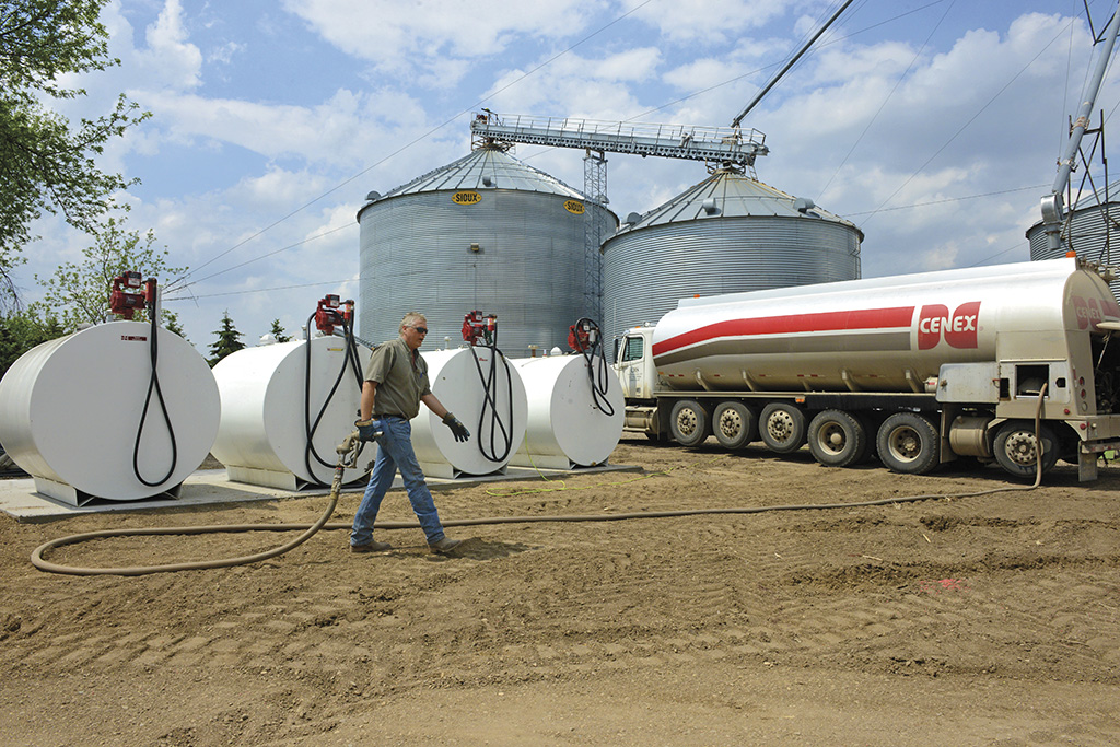 Man walking hose back from tanks to propane truck
