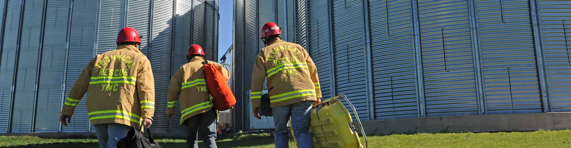 Firefighters wearing PPE walking towards grain silos